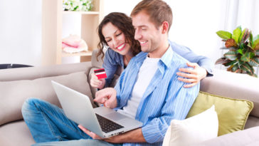 Young couple with Laptop and Credit Card buying online