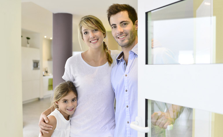 Family standing at front door to invite people in