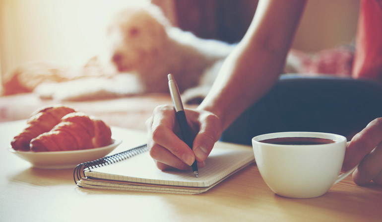 female hands with pen writing on notebook