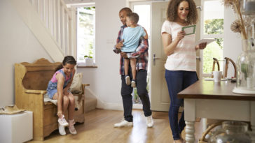 Family In Hallway Returning Home Together