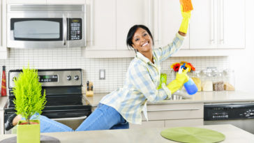 Young woman cleaning kitchen